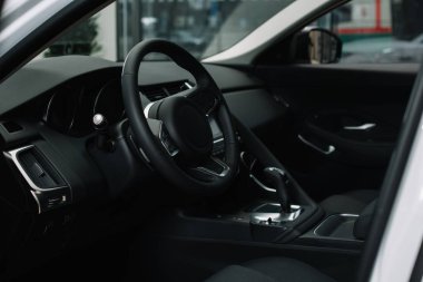 black steering wheel near gear shift handle in luxury car  clipart