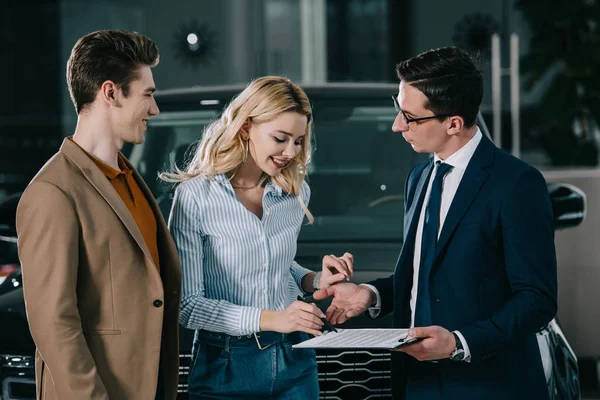 Happy Man Looking Blonde Woman Standing Car Dealer Signing Contract — Stock Photo, Image
