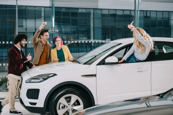 Blonde Girl Showing Thumb Happy Friends Car Showroom — Stock Photo, Image