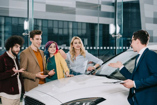Car Dealer Glasses Gesturing While Talking Cheerful Friends White Car — Stock Photo, Image