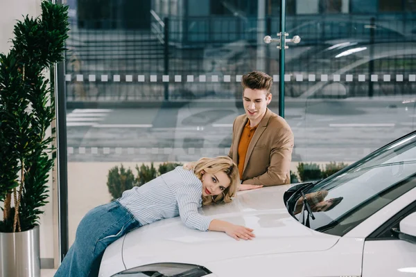 Przystojny Mężczyzna Patrząc Atrakcyjny Blond Dziewczyna Dotykając Biały Samochód — Zdjęcie stockowe