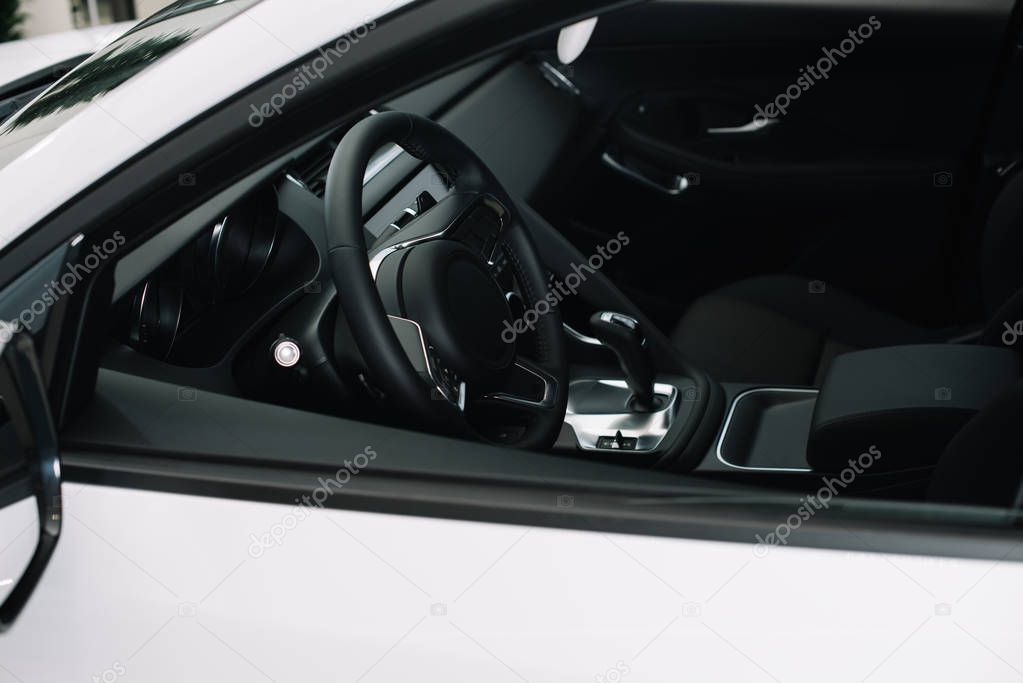  black steering wheel in luxury white automobile in car showroom  