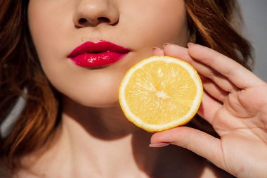 Kırmızı dudaklar limon ile poz ile Redhead kız kırpılmış görünümü