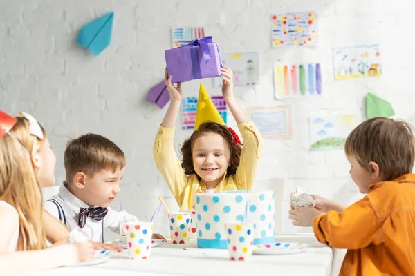 Happy Kid Håller Närvarande När Sitter Vid Bordet Med Vänner — Stockfoto