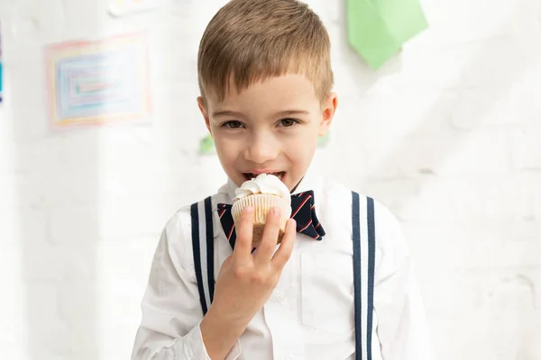 Adorable Preteen Boy Bow Tie Eating Cupcake Looking Camera — Stock Photo, Image