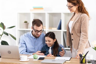 ofiste mutlu kızı yakın akıllı telefon kullanarak neşeli baba 