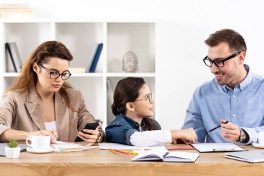 ofiste çalışan neşeli baba bakarak gözlüklü çocuk 