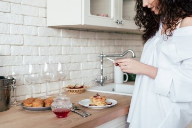 mutfakta akıllı telefon kullanarak beyaz gömlek güzel kız kısmi görünümü