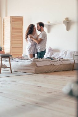 mutlu çift kucaklayan ve yatakta birbirlerine bakarak