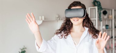 vr kulaklık yatak odasında el sallayarak gülümseyen kız panoramik çekim