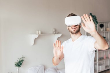 vr kulaklık duygusal adam yatak odasında el sallayarak
