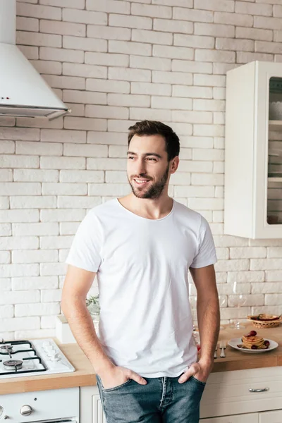 Smiling Man Jeans Standing Hands Pockets Looking Away Kitchen — Stock Photo, Image