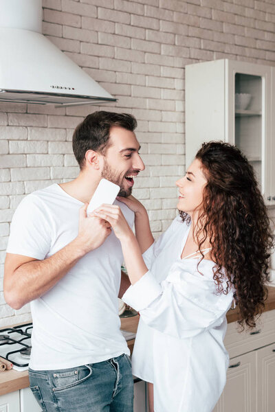 laughing couple looking at each other in kitchen