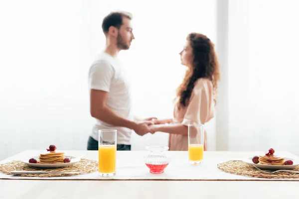 Selective Focus Couple Holding Hands Pancakes Orange Juice Foreground — Stock Photo, Image