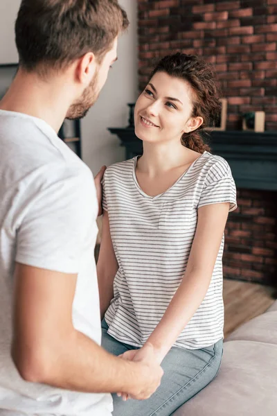 Lyckligt Par Håller Händerna Och Tittar Varandra Vardagsrummet — Stockfoto