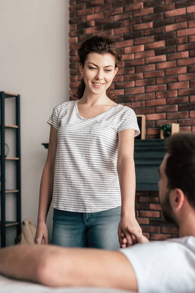 Lachende Jonge Vrouw Die Handen Vasthoudt Met Vriendje Woonkamer — Stockfoto