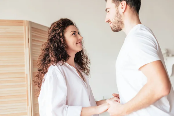 Leende Par Håller Händerna Och Tittar Varandra Sovrummet — Stockfoto