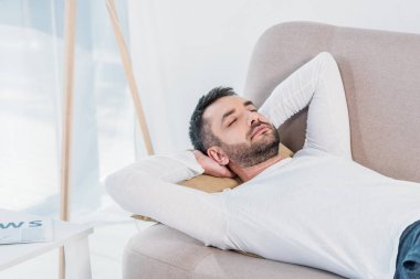 gözleri kapalı yakışıklı sakallı adam ve Eller Arka evde kanepede uyku
