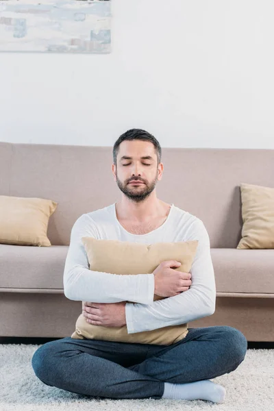 Hombre Guapo Con Los Ojos Cerrados Sentado Alfombra Abrazando Almohada —  Fotos de Stock