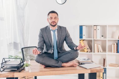gözleri ofis masasında Lotus Pose meditasyon kapalı yakışıklı işadamı