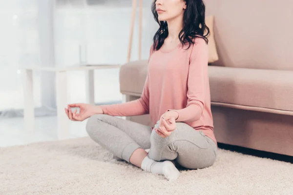 リビングルームで自宅で瞑想を実践ロータスポーズの女性のトリミングされたビュー — ストック写真