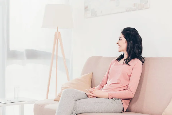 Hermosa Mujer Sonriente Sentada Sofá Con Las Manos Dobladas Casa — Foto de Stock