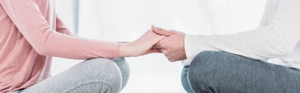 Panoramatický Záběr Muže Ženy Sedícího Lotosové Pozici Meditování Držení Rukou — Stock fotografie