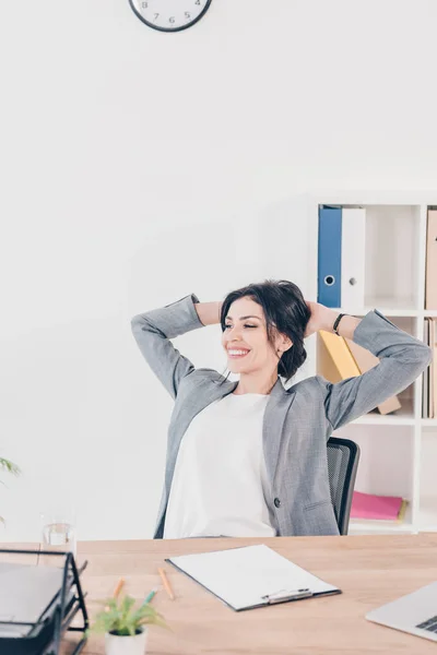 Hermosa Mujer Negocios Sonriente Traje Con Las Manos Cabeza Sentado — Foto de Stock