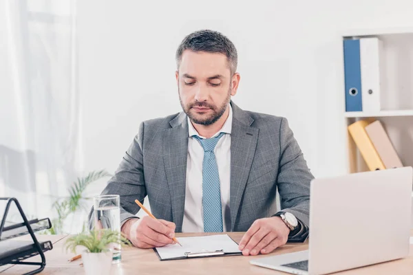 Schöner Geschäftsmann Anzug Sitzt Schreibtisch Und Schreibt Büro — Stockfoto