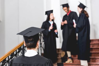üniversitede ayakta mezuniyet kap öğrencinin geri görünümü 