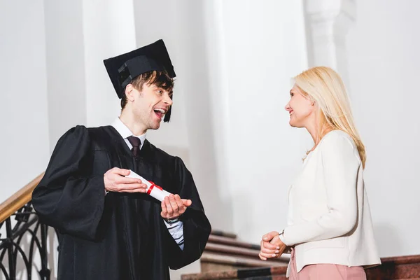 Visão Baixo Ângulo Filho Alegre Segurando Diploma Olhando Para Mãe — Fotografia de Stock