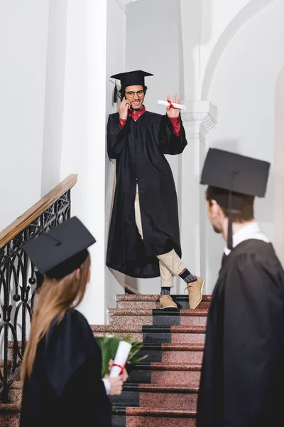 Homem Alegre Falando Smartphone Acenando Mão Para Alunos Bonés Graduação — Fotografia de Stock