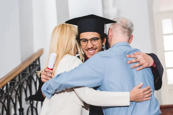 Tillbaka Syn Mogna Föräldrar Kramar Lycklig Son Glasögon Och Examen — Stockfoto