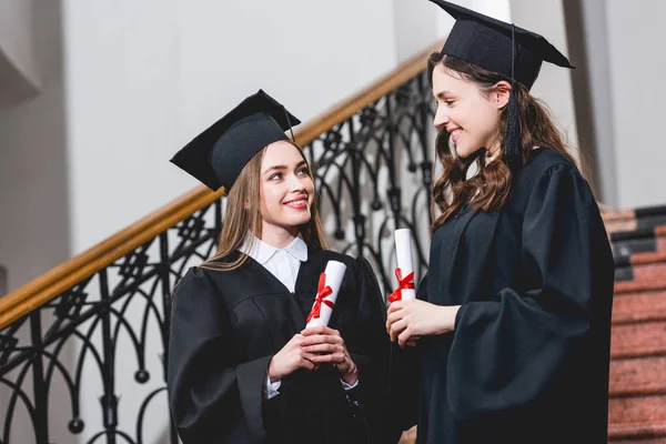 Chicas Bonitas Vestidos Graduación Con Diplomas Sonriendo Universidad —  Fotos de Stock