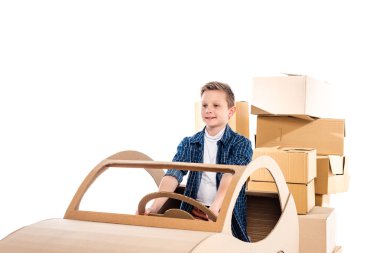 adorable boy playing with cardboard car Isolated On White with copy space clipart