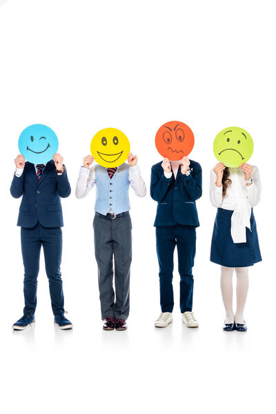 школьники в формальной одежде закрывают лица карточками с различными выражениями лица на белом
