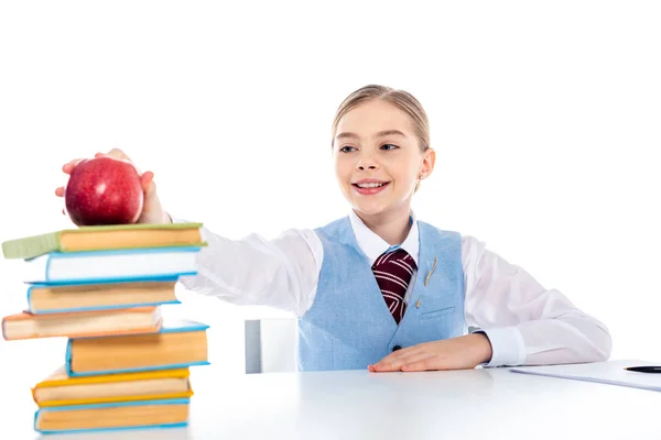 Colegiala Sonriente Sentada Escritorio Con Libros Buscando Manzana Aislada Blanco —  Fotos de Stock