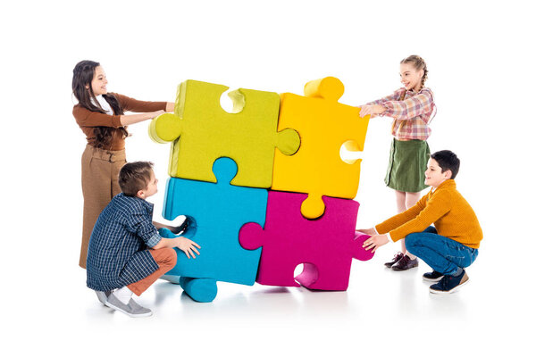 happy kids playing with jigsaw puzzle pieces on white 