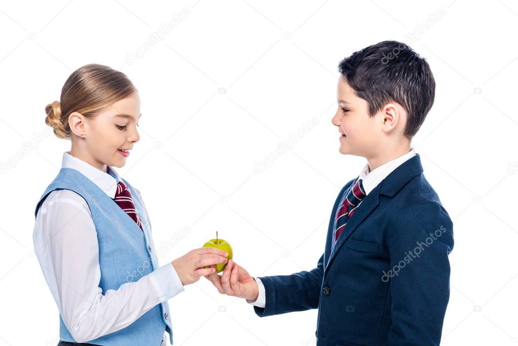 schoolchildren in formal wear sharing apple Isolated On White