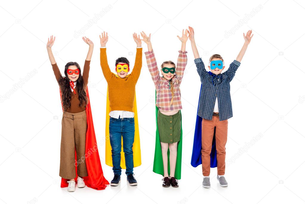 happy kids in superhero costumes and masks with Raised Hands On White