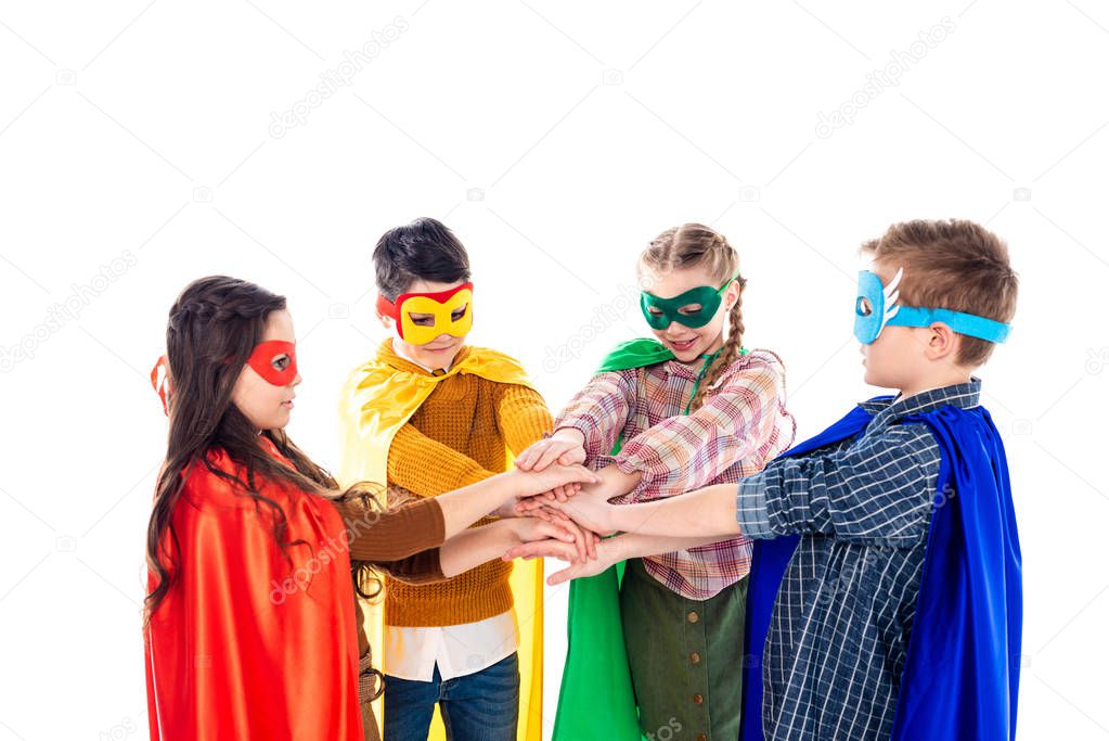kids in superhero costumes and masks Stacking Hands Isolated On White