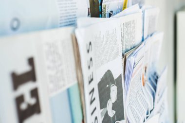 selective focus of different print newspapers on stand clipart