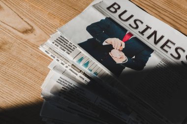 gölge ile ahşap masa üzerinde iş baskı gazete yığını