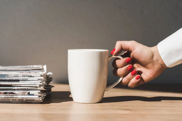 Vista Recortada Mujer Sosteniendo Taza Blanca Mesa Madera Cerca Pila — Foto de Stock