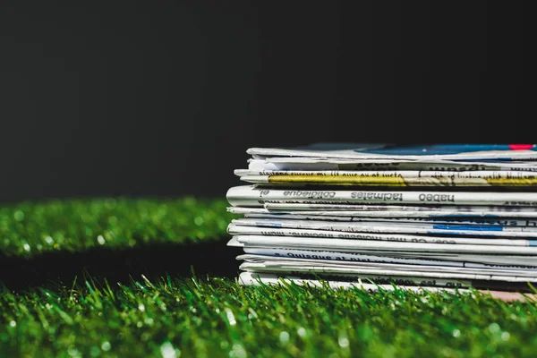 Stack Different Print Newspapers Fresh Green Grass Isolated Black — Stock Photo, Image