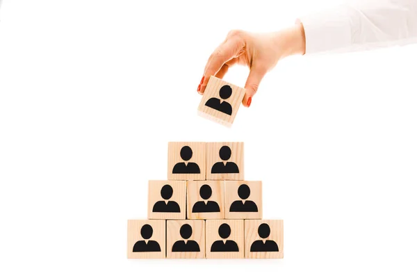 Cropped view of woman picking up one wooden block with black human icon from pyramid isolated on white — Stock Image Cropped View Woman Picking One Wooden Block Black Human Icon Stock Photo