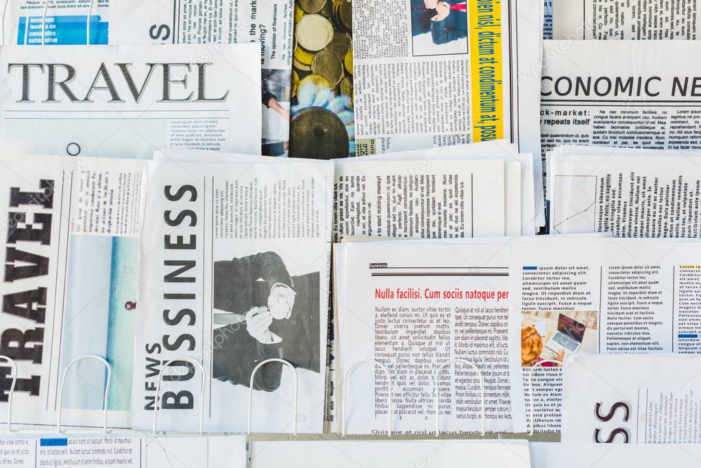 different print business and travel newspapers on stand