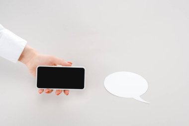 boş kağıt kesme konuşma balonu yakınında boş ekran ile akıllı telefon tutan kadın kırpılmış görünümü