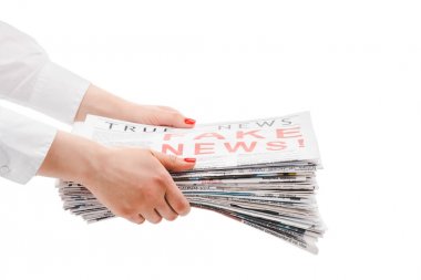cropped view of woman holding pile of newspapers isolated on white clipart