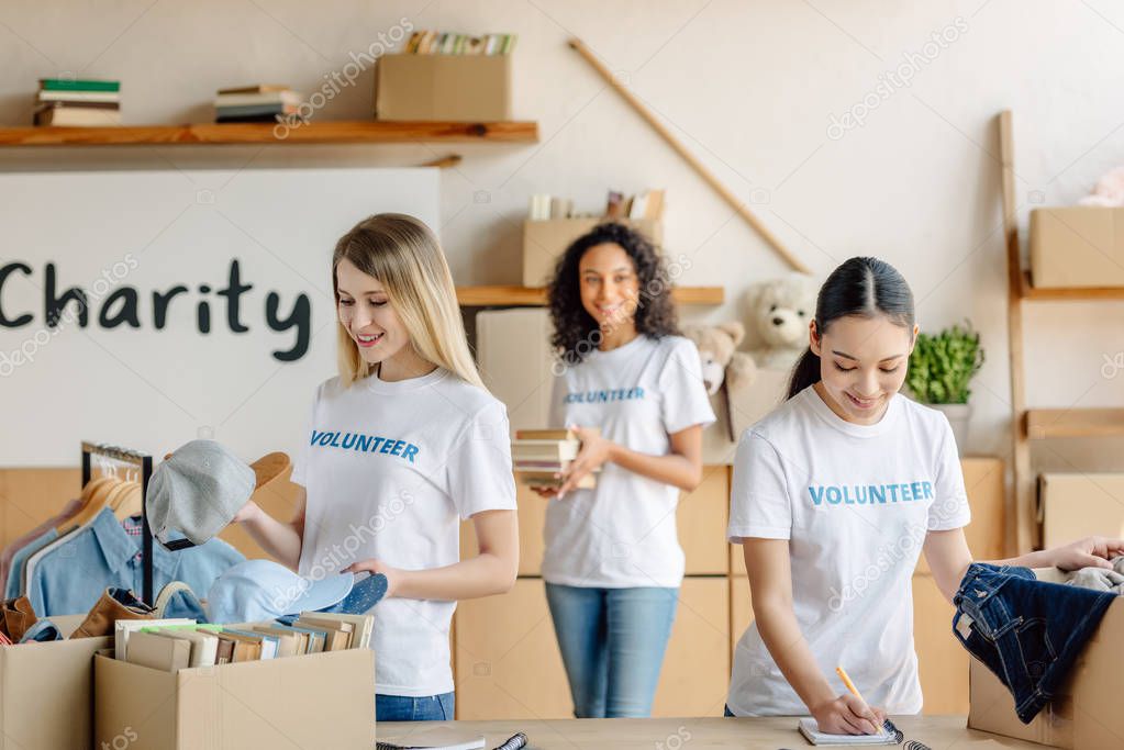 selective focus of three multicultural volunteers working in charity center
